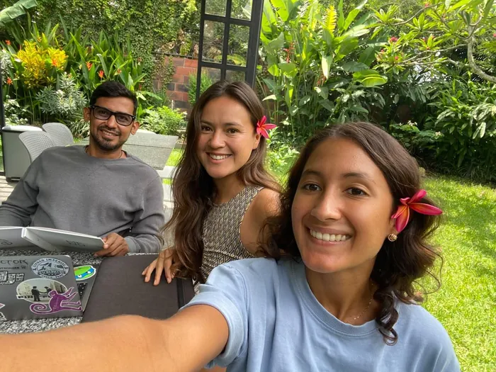 The Tours Alegría founders Rousse, Kaleb and Melissa smiling together in a garden