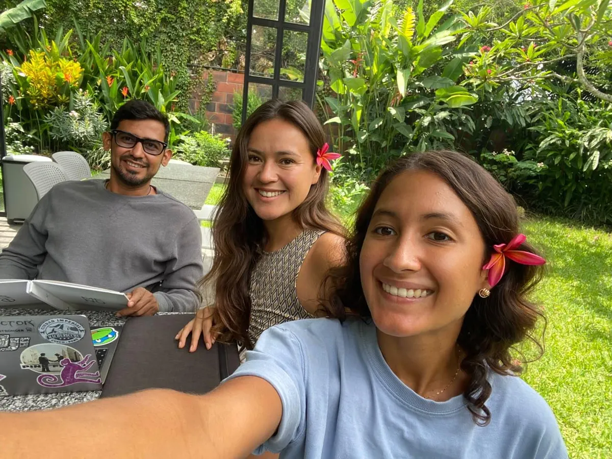 The Tours Alegría founders Rousse, Kaleb and Melissa smiling together in a garden